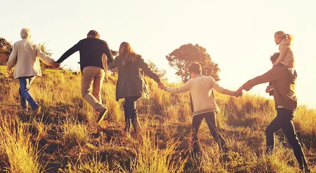 family holding hands walking uphill